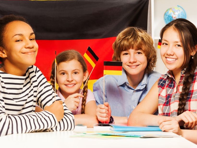 grupo de estudiantes en mesa con banderas de alemania